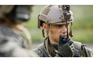 Soldier in full uniform using walkie talkie