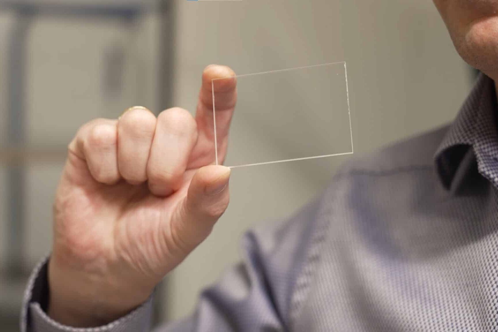 man holding a small piece of cleartech acrylic cover glass